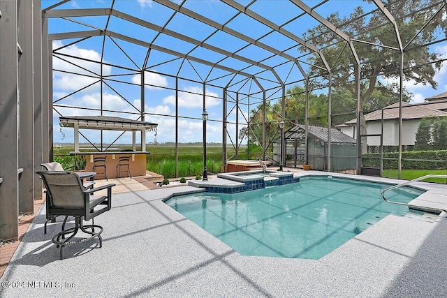 view of swimming pool with glass enclosure, a pool with connected hot tub, outdoor dry bar, and a patio