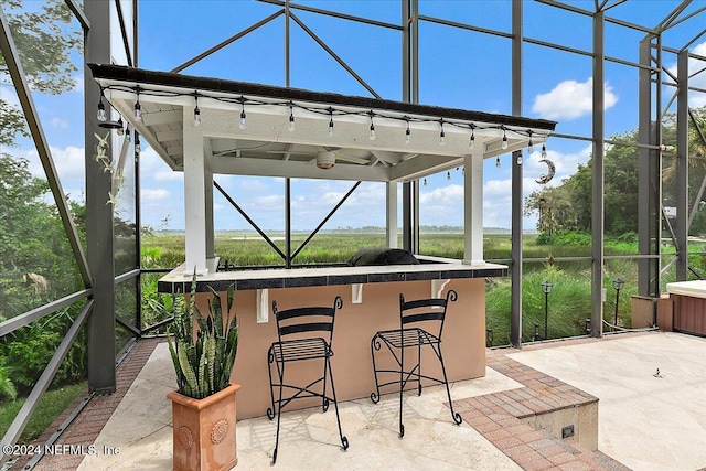 view of patio / terrace featuring a lanai and outdoor dry bar