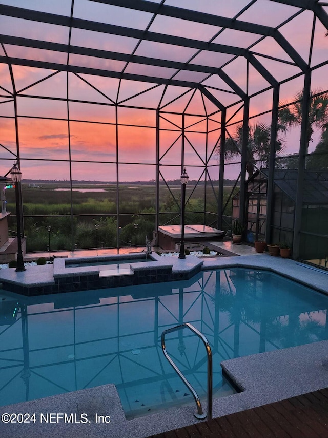 view of pool featuring glass enclosure, a patio area, and a pool with connected hot tub