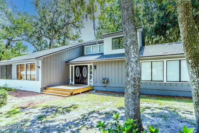 rear view of property featuring a wooden deck