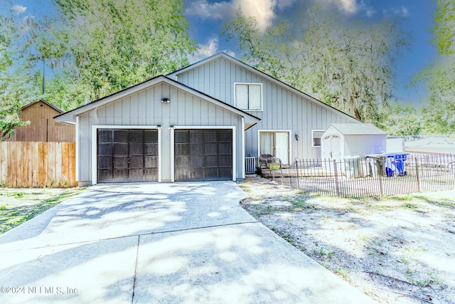 view of front of house with fence, driveway, and an attached garage