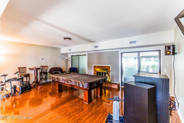 rec room featuring pool table, a textured ceiling, and dark hardwood / wood-style flooring