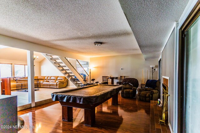 playroom featuring a textured ceiling, hardwood / wood-style floors, and pool table