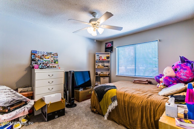 carpeted bedroom featuring ceiling fan and a textured ceiling