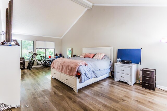 bedroom with high vaulted ceiling, hardwood / wood-style floors, and beam ceiling