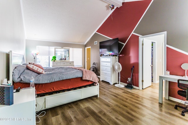 bedroom with vaulted ceiling with beams and wood-type flooring