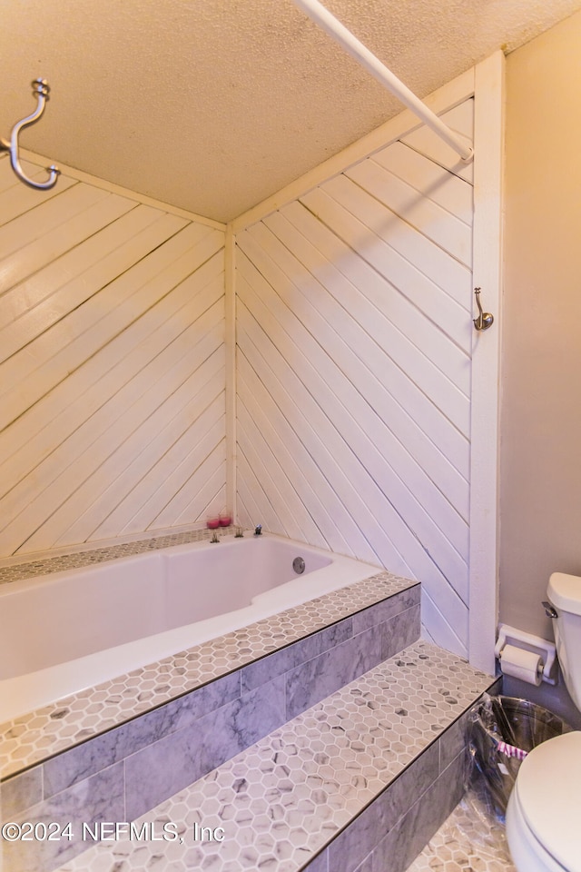 bathroom featuring tile patterned flooring, wooden walls, toilet, and a textured ceiling