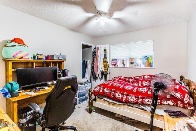 carpeted bedroom featuring ceiling fan and a textured ceiling