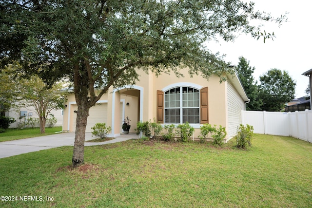 mediterranean / spanish-style home featuring a garage and a front yard