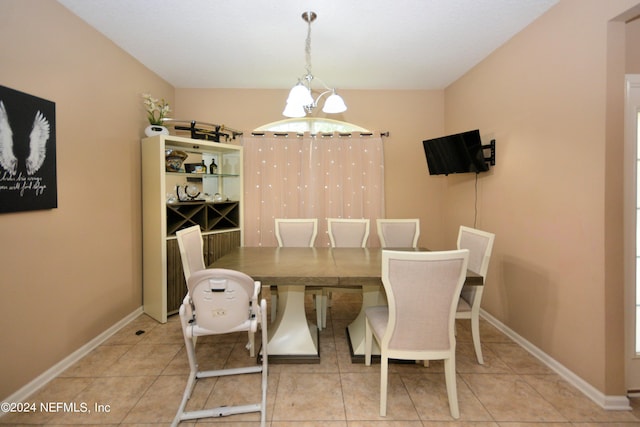 tiled dining area featuring an inviting chandelier