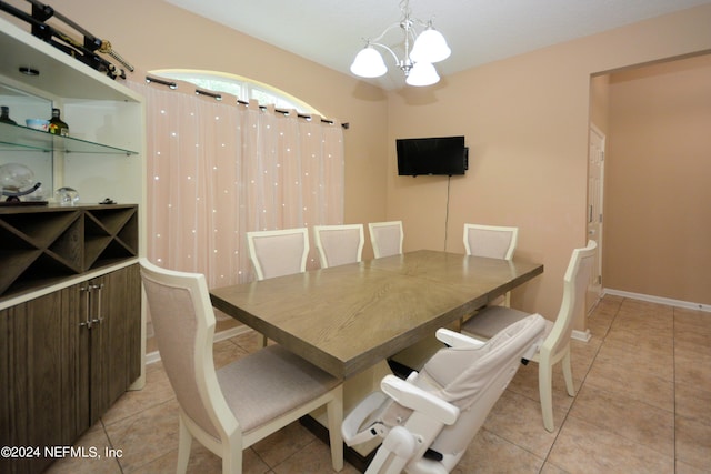 dining space with light tile patterned flooring and a notable chandelier