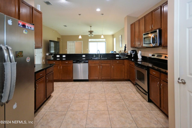 kitchen featuring light tile patterned flooring, appliances with stainless steel finishes, pendant lighting, sink, and kitchen peninsula