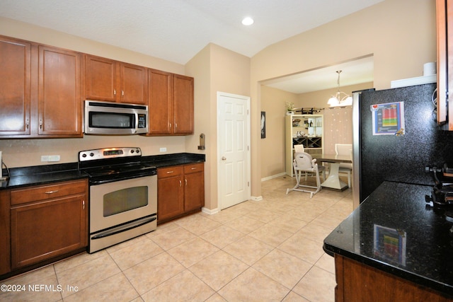 kitchen featuring lofted ceiling, hanging light fixtures, light tile patterned floors, and appliances with stainless steel finishes