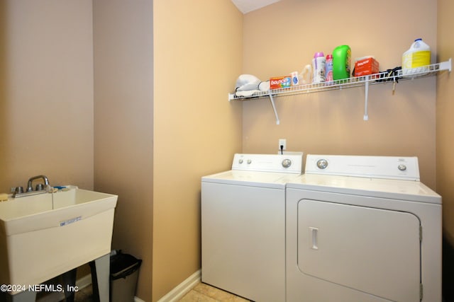 laundry area featuring sink, light tile patterned floors, and independent washer and dryer