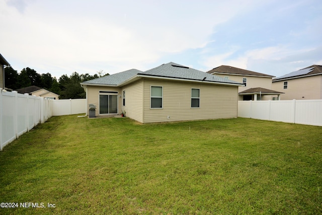 back of house featuring a lawn