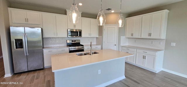 kitchen with white cabinetry, appliances with stainless steel finishes, backsplash, pendant lighting, and sink