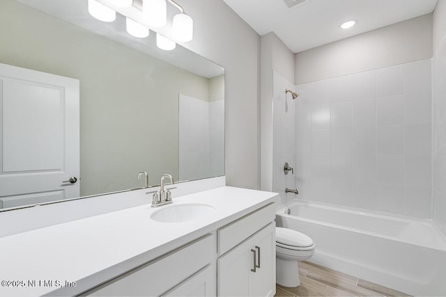 full bathroom featuring toilet, tub / shower combination, wood-type flooring, and vanity