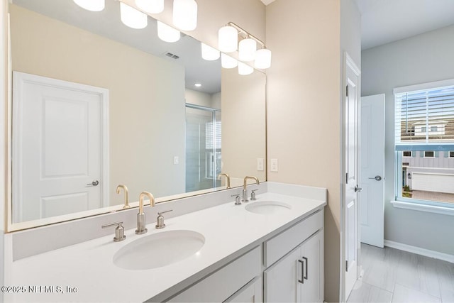 bathroom with a shower with shower door and vanity