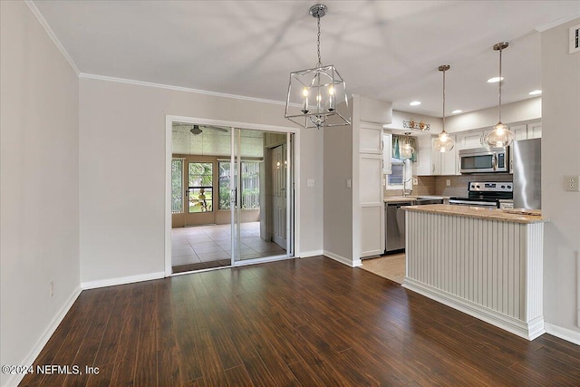 kitchen featuring white cabinetry, hanging light fixtures, stainless steel appliances, and hardwood / wood-style flooring