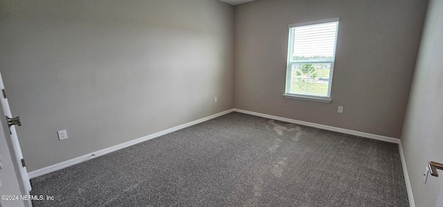 unfurnished room with dark colored carpet