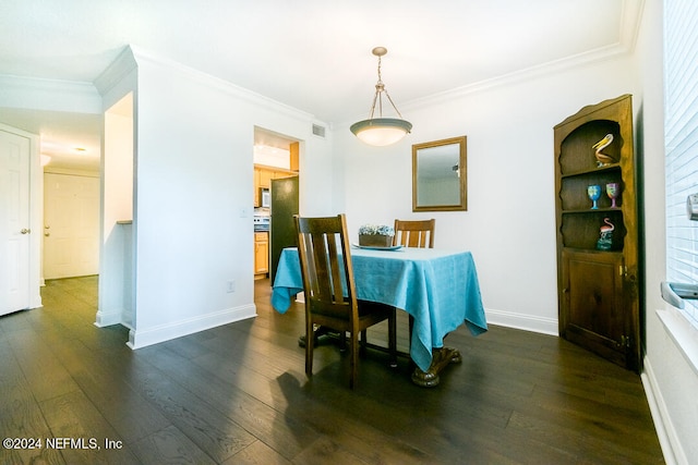 dining area with ornamental molding and dark hardwood / wood-style floors