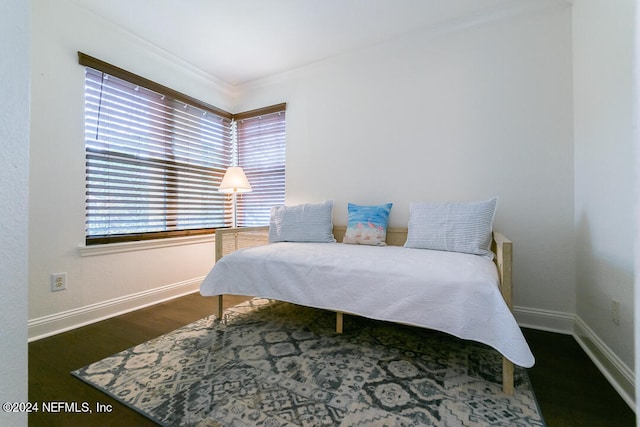 bedroom with dark hardwood / wood-style flooring and ornamental molding