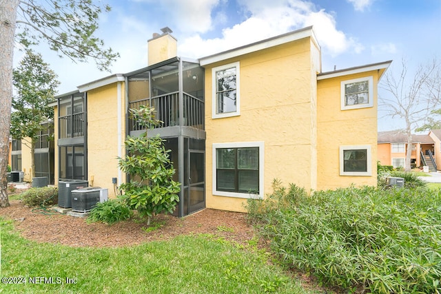 back of house with central AC unit