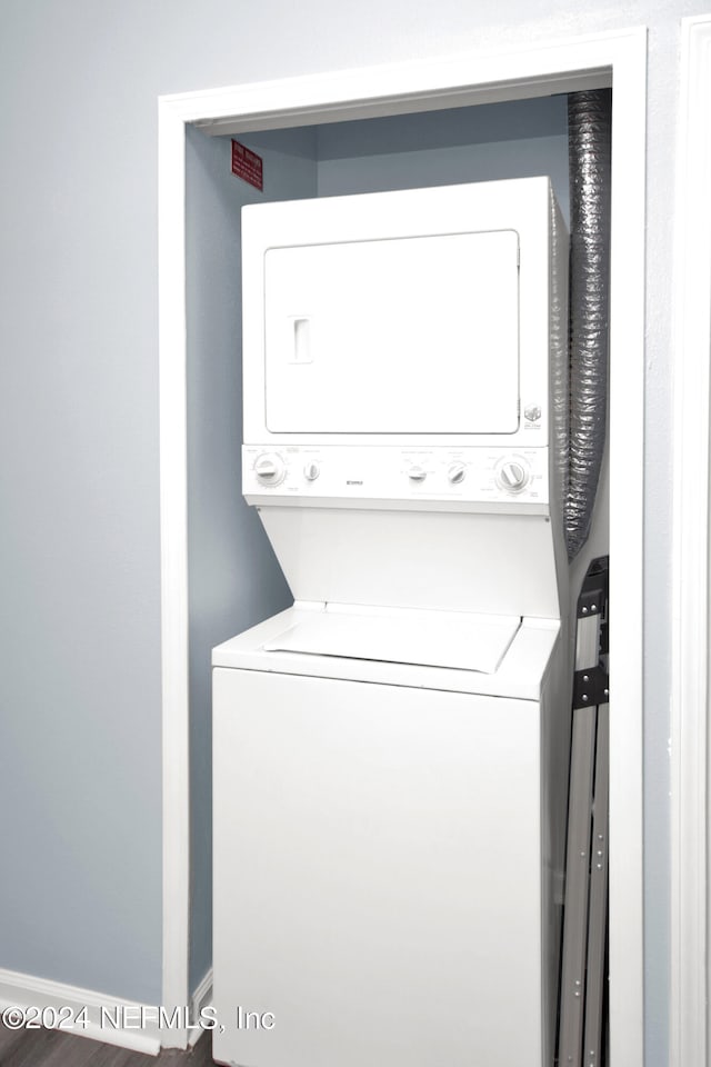 washroom featuring stacked washer / dryer and wood-type flooring