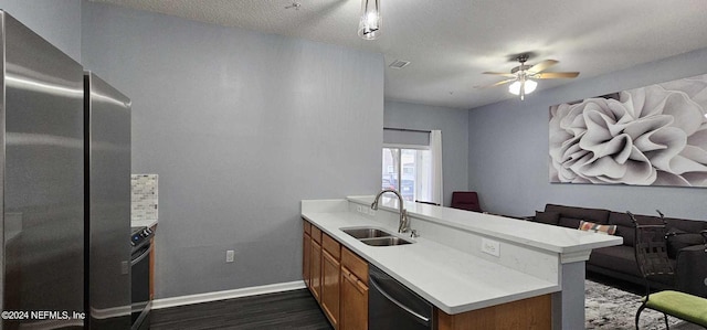 kitchen featuring appliances with stainless steel finishes, sink, a textured ceiling, ceiling fan, and dark wood-type flooring