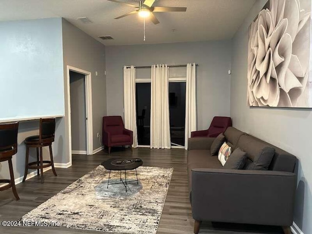 living room with dark hardwood / wood-style floors and ceiling fan