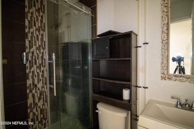 bathroom with toilet, a shower with door, and vanity