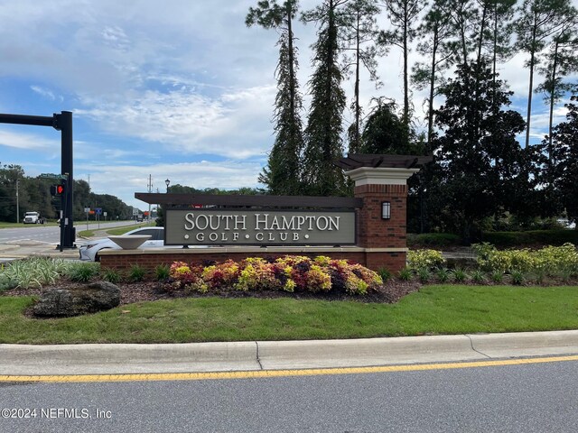 community / neighborhood sign with a yard