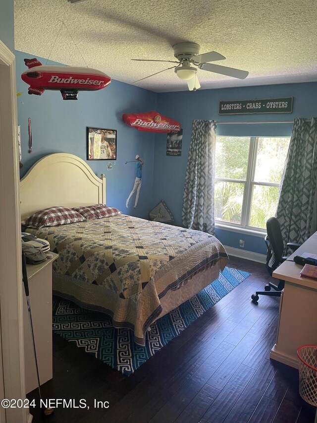 bedroom with dark hardwood / wood-style floors, a textured ceiling, and ceiling fan