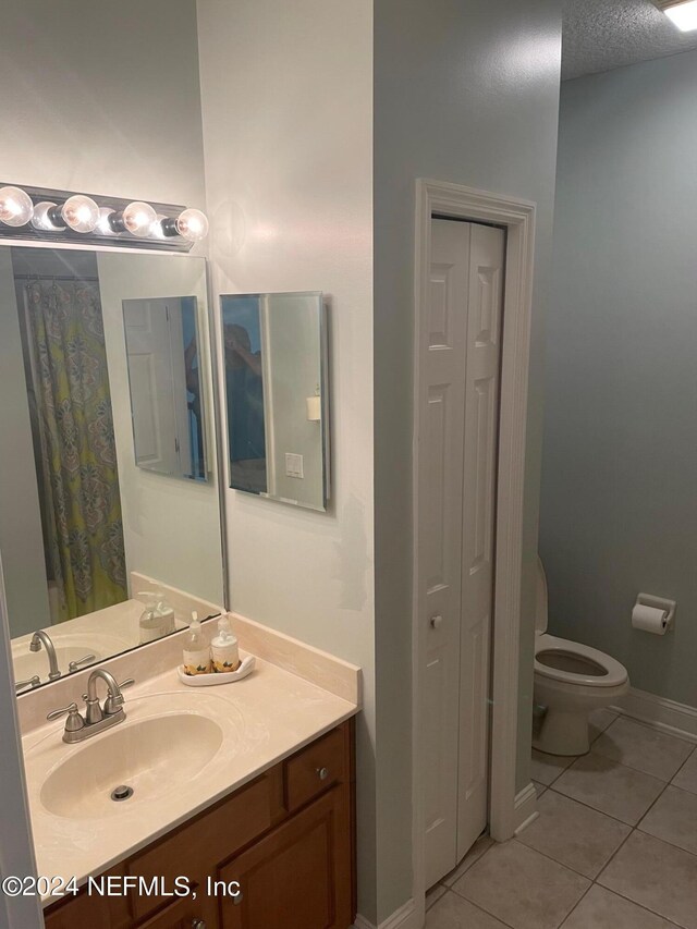 bathroom with vanity, toilet, and tile patterned floors