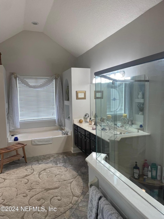 bathroom with plus walk in shower, vaulted ceiling, and vanity