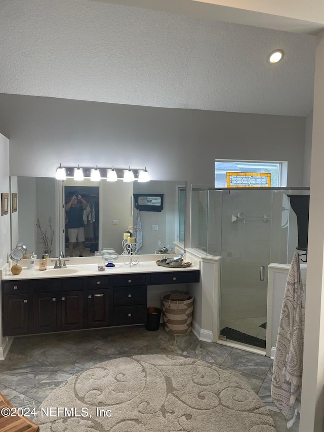 bathroom featuring vanity, a textured ceiling, and an enclosed shower