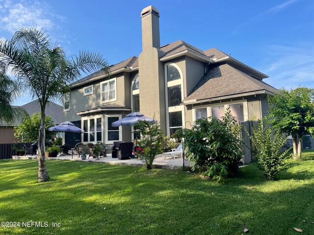 back of property with a patio and a lawn