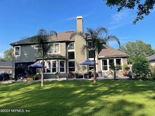 rear view of property featuring a yard and a patio area