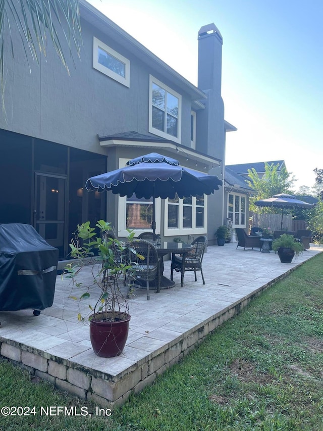 back of property featuring an outdoor living space and a patio area