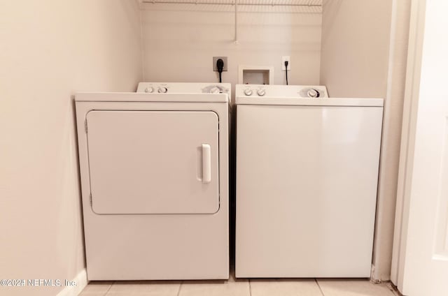 washroom featuring laundry area, independent washer and dryer, and light tile patterned floors