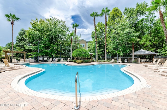 pool with a patio, fence, and a pergola