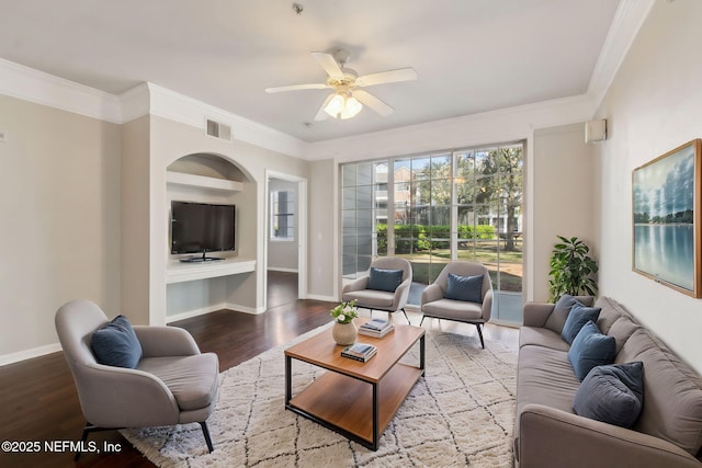 living room with ornamental molding, visible vents, baseboards, and wood finished floors