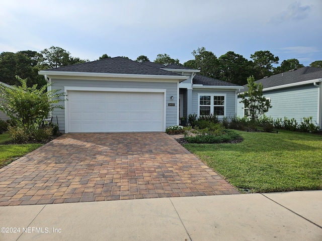 ranch-style house featuring a garage, a front lawn, and decorative driveway