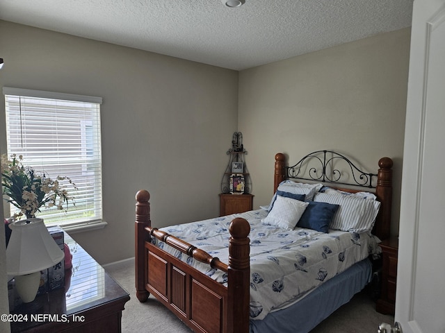 bedroom featuring a textured ceiling and light colored carpet