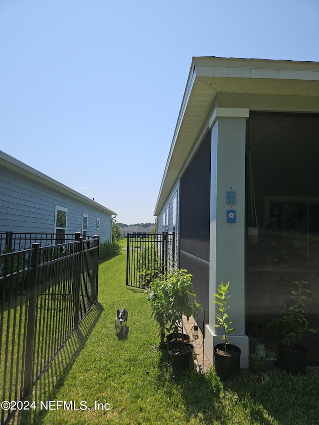 view of home's exterior with a lawn and fence