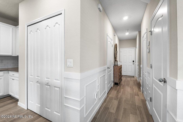 hallway featuring a textured ceiling and hardwood / wood-style floors