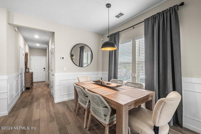 dining room with dark wood-type flooring and a textured ceiling