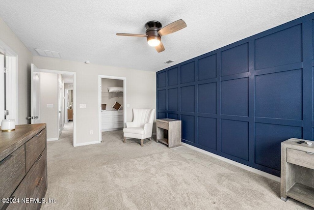 unfurnished room featuring ceiling fan, a textured ceiling, and light carpet