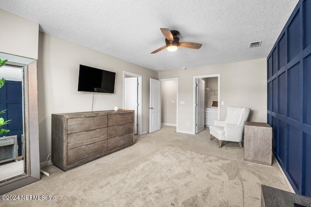 interior space featuring light carpet, a textured ceiling, and ceiling fan