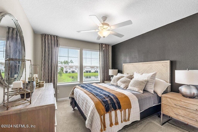 bedroom with ceiling fan, carpet flooring, and a textured ceiling